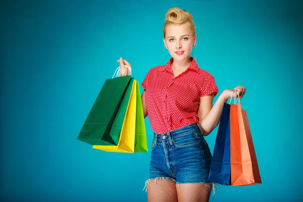 Pinup menina com sacos de compras comprar roupas . — Fotografia de Stock