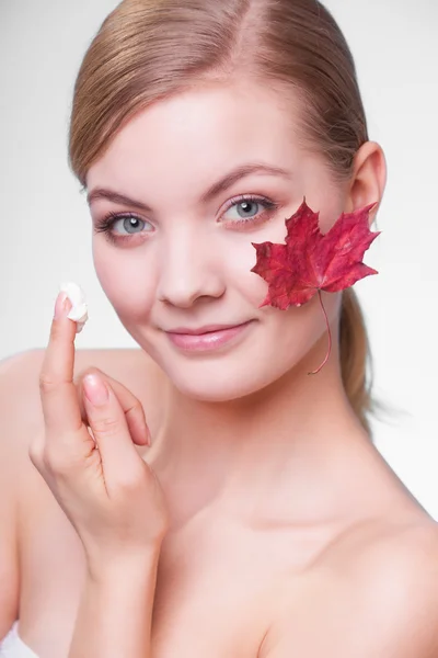 Gezicht van jonge meisje met rood esdoornblad. — Stockfoto