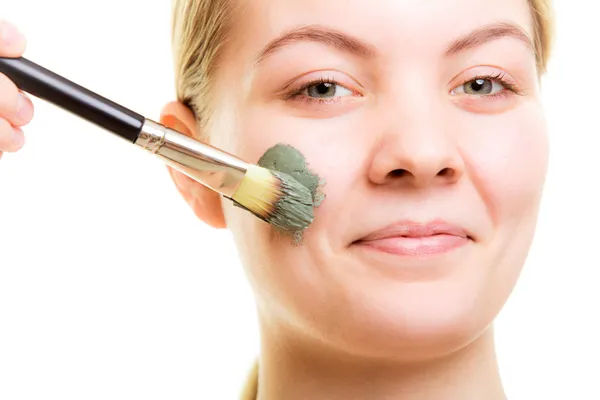 Mujer aplicando mascarilla de barro en la cara . — Foto de Stock