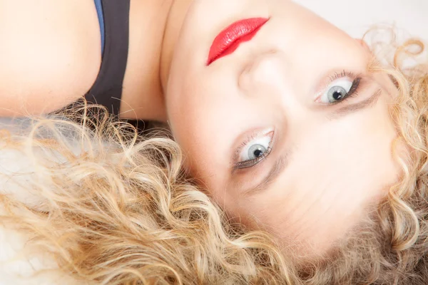 Porträtt vacker blond flicka gör upp liggande på golvet studio skott — Stockfoto