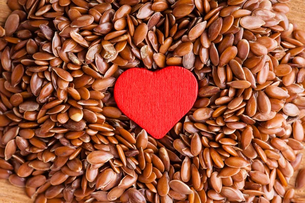 Flax seeds linseed as food background and red heart — Stock Photo, Image