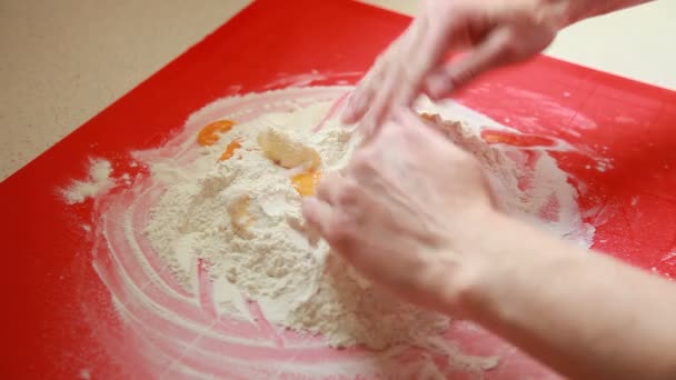 Female hands of housewife or chef making dough on the red pastry board in domestic kitchen — Stock Video