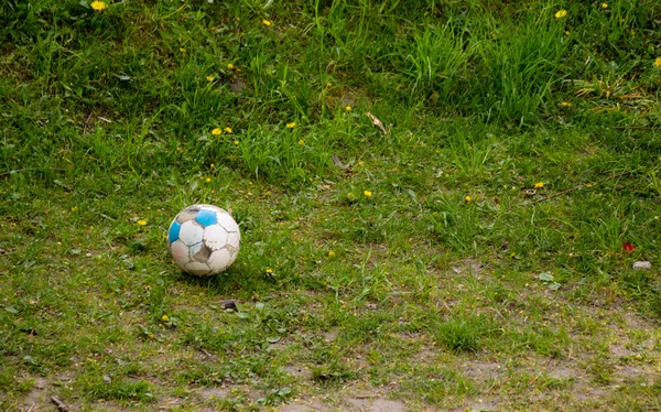 Deporte. Vieja pelota de fútbol sucio en la hierba. Fútbol . — Foto de Stock