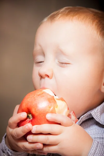 Bonito bebê menino comer vermelho maçã fruta — Fotografia de Stock