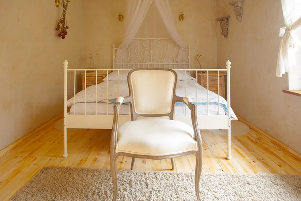 Interior of bedroom. Canopy bed and retro chair. — Stock Photo, Image