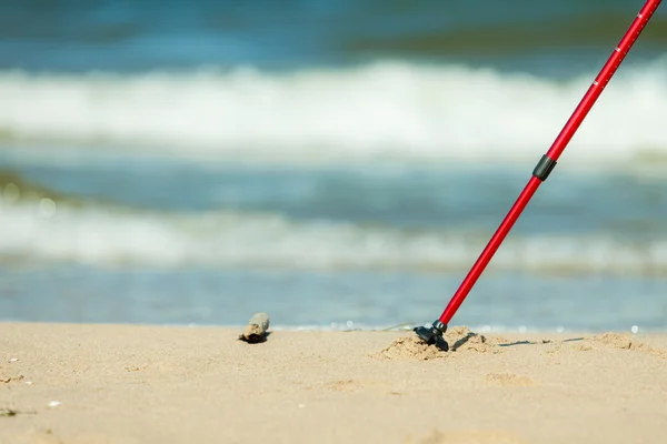 Caminar nórdico. Palos rojos en la playa de arena —  Fotos de Stock