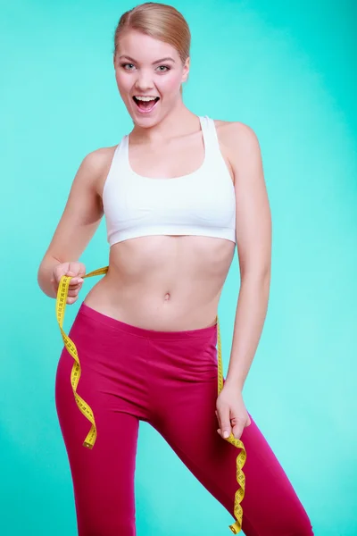 Chica en forma de mujer fitness con cinta métrica que mide su cintura —  Fotos de Stock
