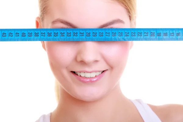 Fitness girl fit woman covering her eyes with measuring tape — Stock Photo, Image