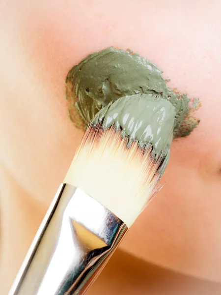 Woman applying clay mud mask on face. — Stock Photo, Image