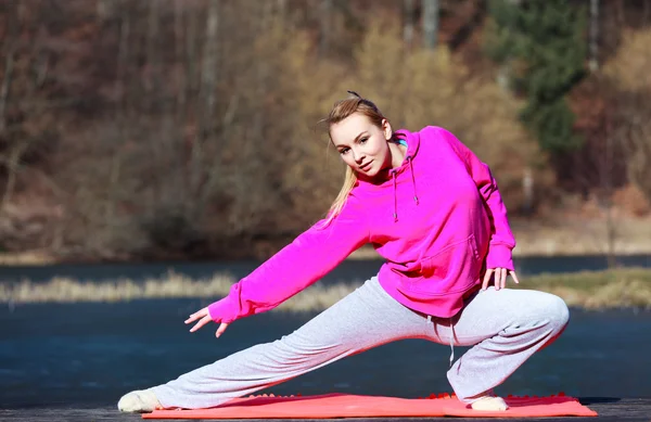 Donna adolescente in tuta da ginnastica facendo esercizio sul molo all'aperto — Foto Stock