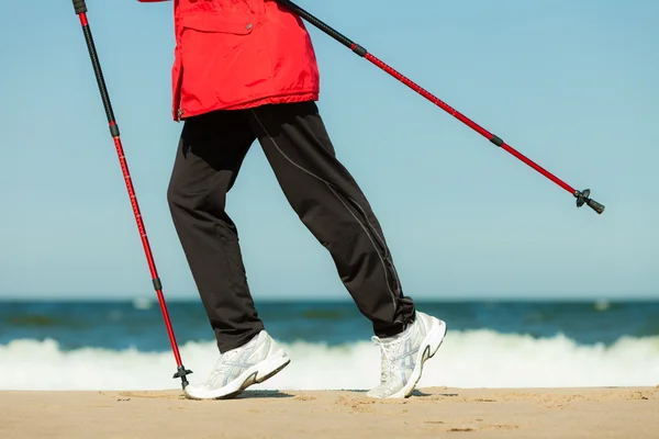 Caminhada nórdica. Pernas femininas caminhadas na praia. — Fotografia de Stock