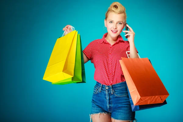 Pinup ragazza con borse della spesa chiamando al telefono — Foto Stock