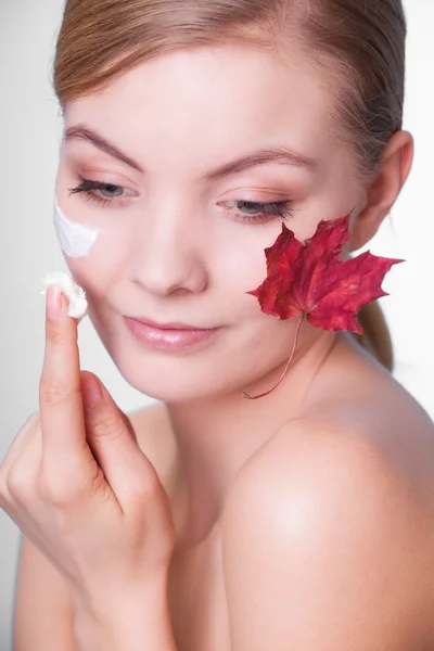 Gezicht van jonge vrouw meisje met rood esdoornblad. — Stockfoto