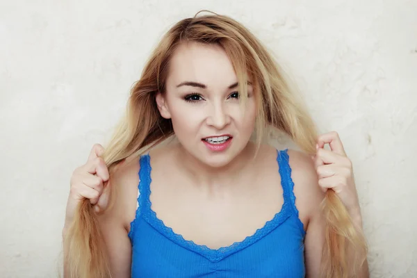 Loira adolescente mostrando seu cabelo seco danificado — Fotografia de Stock