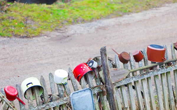 Vieux pots colorés plats sur clôture en bois en plein air . — Photo