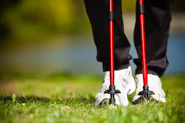 Nordic walking. Ženské nohy pěší turistika v parku. — Stock fotografie