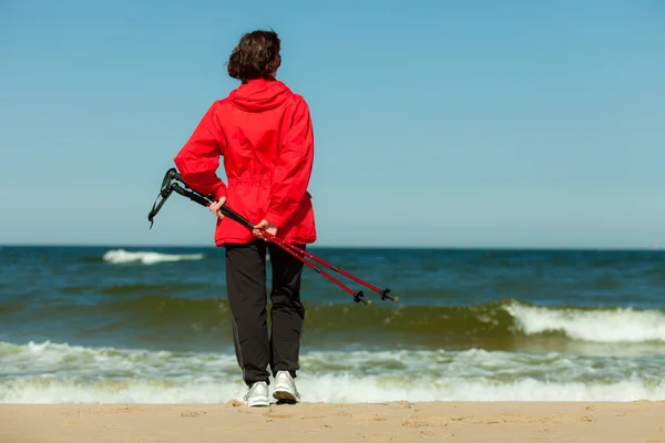 Нордическая ходьба. Женщина, гуляющая по пляжу. — стоковое фото