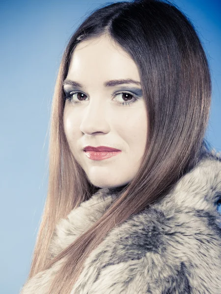 Young woman in fur coat on blue. — Stock Photo, Image