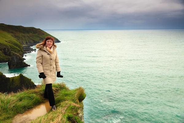 Vrouw staand op rock rotsmassief door de Oceaan — Stockfoto