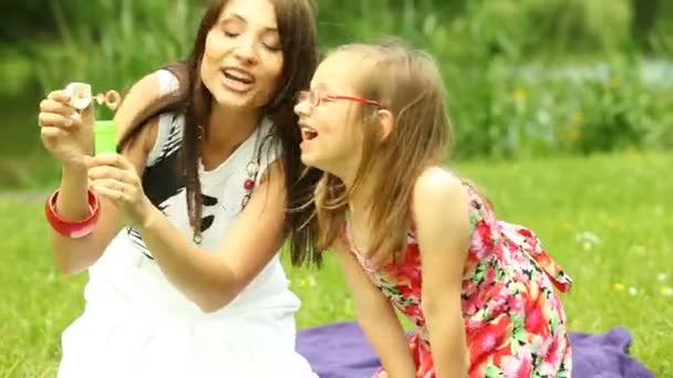 Jeune femme et fille souffler une bulle de savon — Video