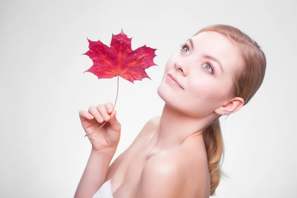 Portrait of young woman with red maple leaf. — Stock Photo, Image