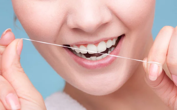 Dziewczyna, czyszczenie zębów z nici dentystyczne. — Zdjęcie stockowe
