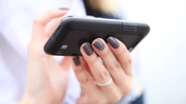 Closeup των χεριών της γυναίκας που χρησιμοποιούν κινητό τηλέφωνο. — Αρχείο Βίντεο