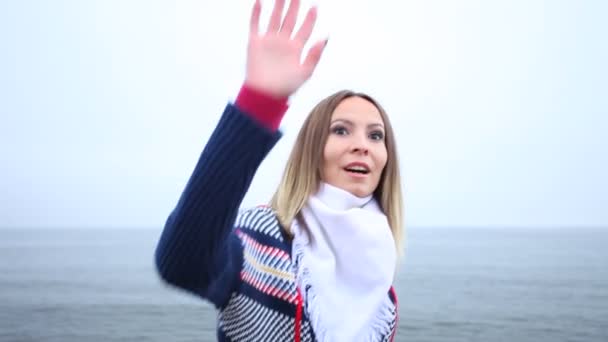 Woman standing on the shore waving — Stock Video