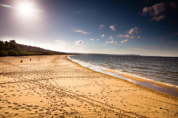 Blick auf bewölkten Himmel am Meer mit Fußabdrücken am Strand — Stockfoto