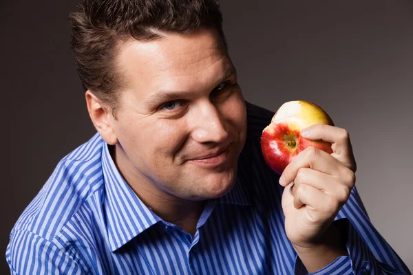 Hombre feliz comiendo fruta de manzana — Foto de Stock