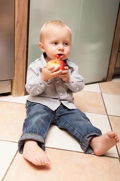 Kleines Kind isst zu Hause Apfelfrüchte — Stockfoto