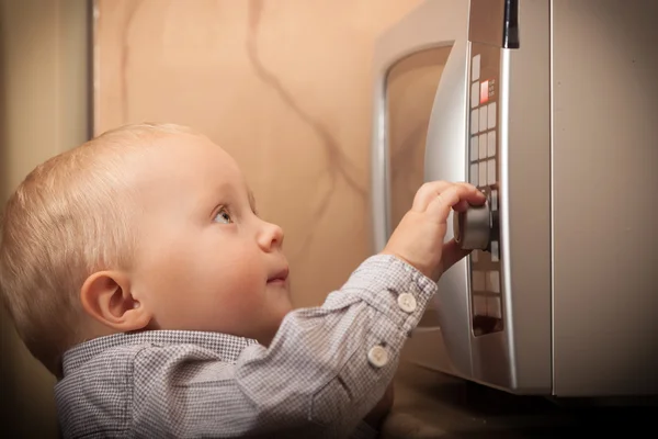 Child playing with timer of microwave oven — Stock Photo, Image