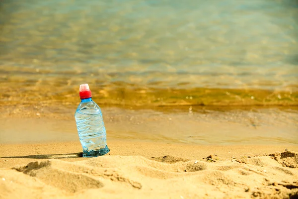Botella de bebida de agua en una playa de arena . —  Fotos de Stock