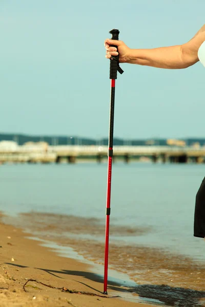 Severské hůl v ženské ruce na písečné pláži. — Stock fotografie