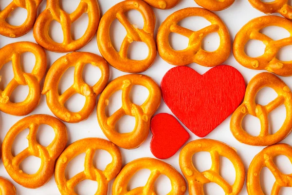 Dia dos Namorados pretzels padrão de fundo e coração vermelho . — Fotografia de Stock