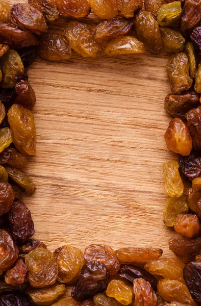 Border of raisin on wooden background — Stock Photo, Image