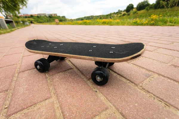 Osamělý skateboard paluba venkovní na dlažbě kámen — Stock fotografie