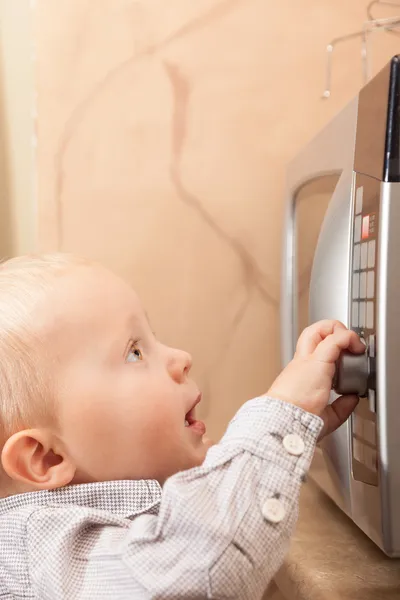 Boy  playing with timer of microwave oven Royalty Free Stock Images