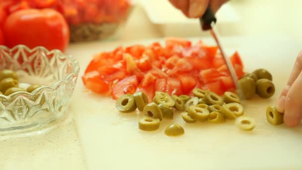 Hände einer Frau schneiden mit einem Küchenmesser grünes Olivengemüse. — Stockvideo