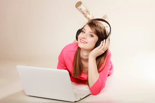 Девушка с наушниками и ноутбуком слушает музыку — стоковое фото
