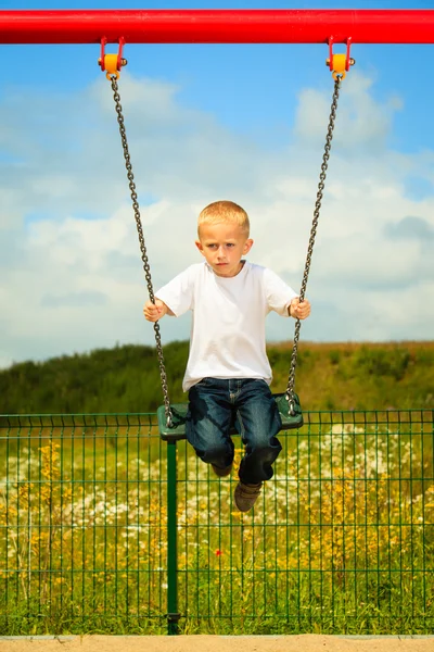 Little blonde boy  having fun on a swing outdoor — Stock Photo, Image