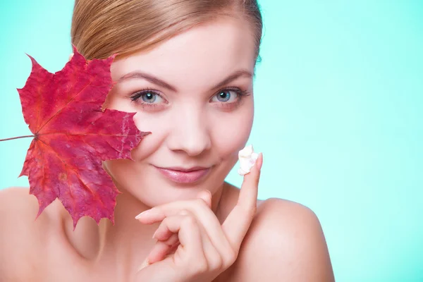 Gezicht van jonge vrouw met rood esdoornblad. — Stockfoto