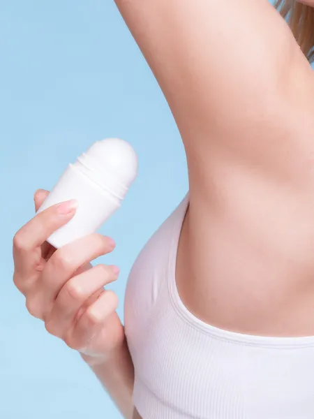 Flicka tillämpa stick deodorant i armhålan. — Stockfoto