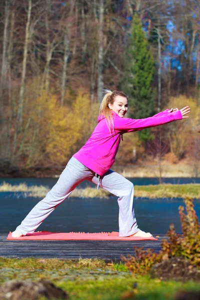 Teenage girl in tracksuit doing exercise on pier outdoor — Stock Photo, Image