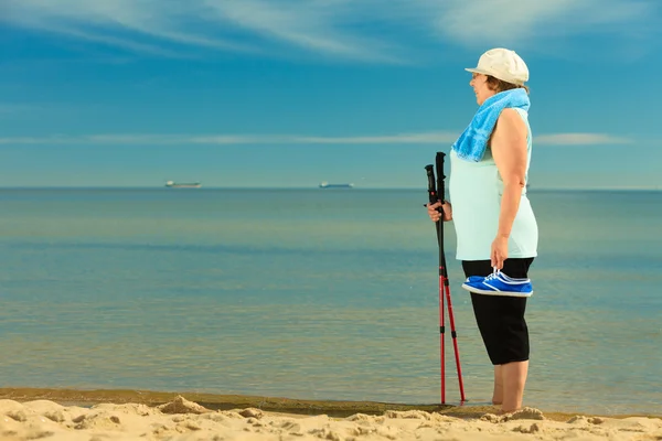 年长的活跃妇女在海滩上散步 — 图库照片