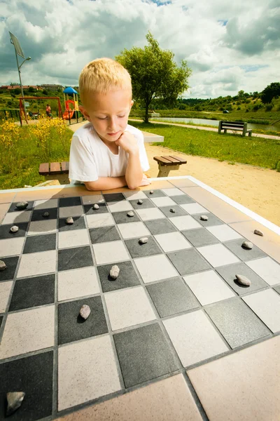 Dítě hrát dárky nebo šachovnice desková hra venkovní — Stock fotografie