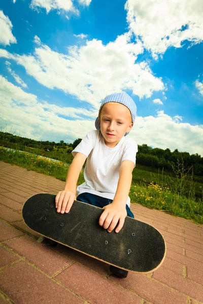 Skater boy bambino con il suo skateboard . — Foto Stock