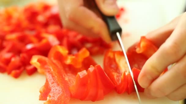 Szeletelés, konyhai kés piros édes paprika nő kezében — Stock videók