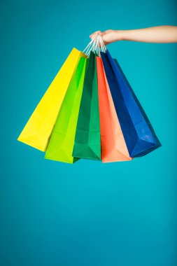 Colorful shopping bags in female hand. clipart