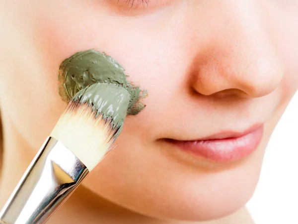 Mujer aplicando mascarilla de barro en la cara . —  Fotos de Stock